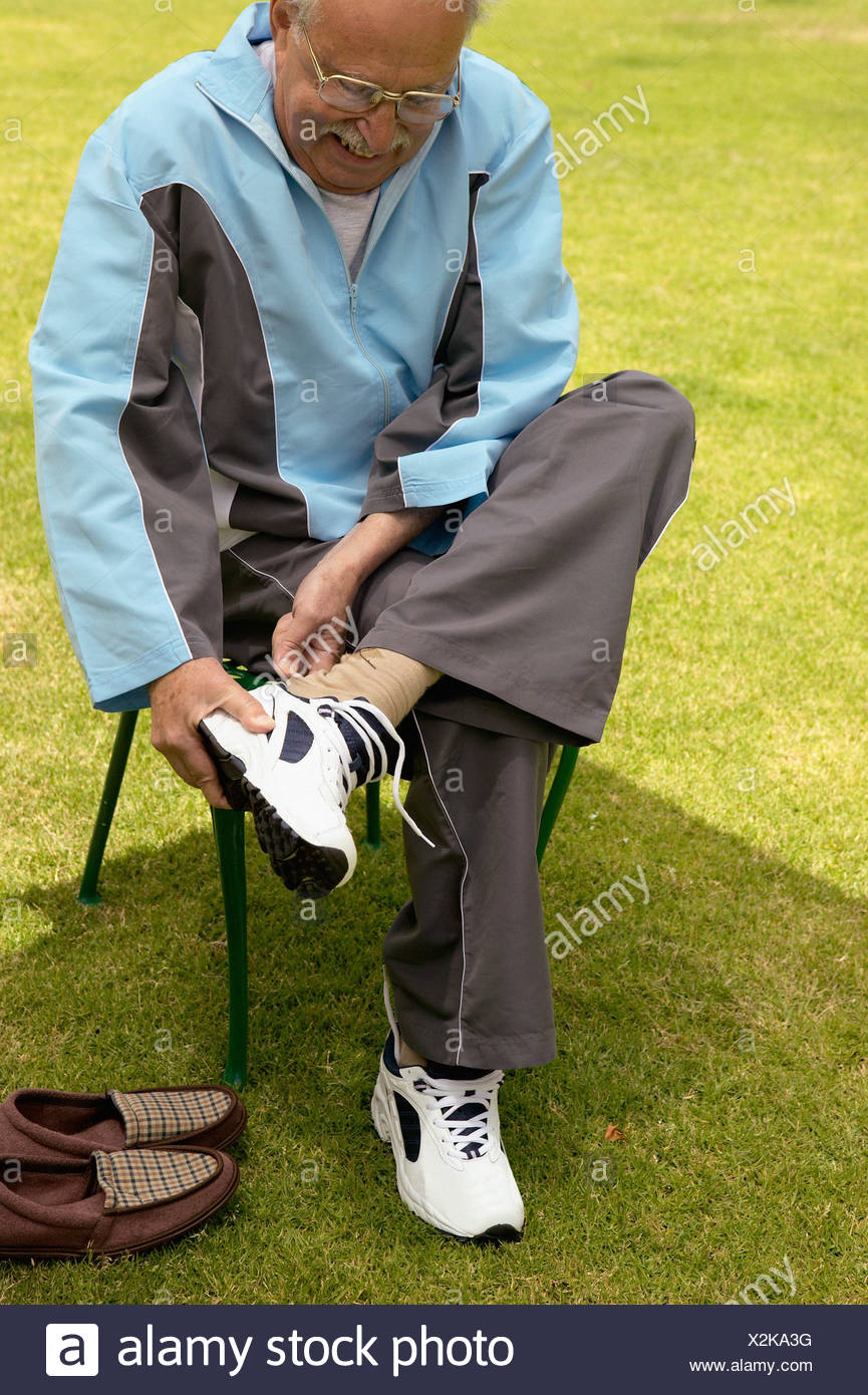 senior-man-putting-trainers-on-X2KA3G.jpg