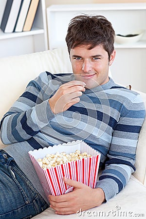 handsome-young-man-eating-popcorn-lying-sofa-16263044.jpg