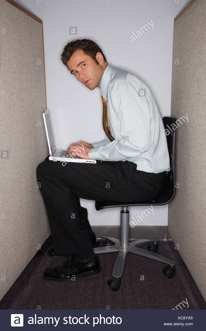 man-on-laptop-in-tiny-cubicle-XC8YA5.jpg